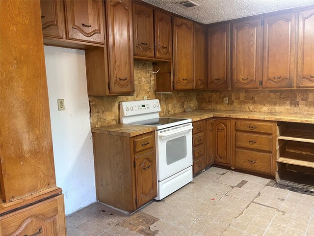 6645 Onyx Dr N, North Richland Hills, TX 76180 - kitchen with white electric range oven, brown cabinets, and a textured ceiling