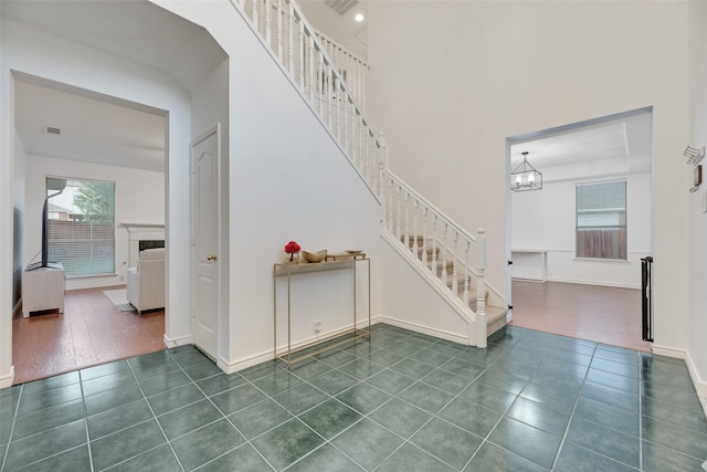 2904 Champlin Ct, Richardson, TX 75082 - stairs featuring tile patterned flooring, a chandelier, baseboards, and a towering ceiling