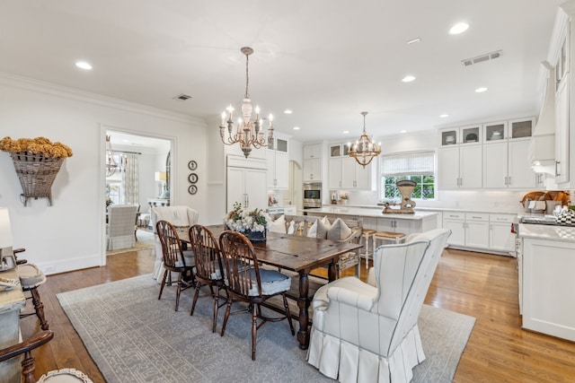 dining space featuring a chandelier, crown molding, light wood-style flooring, recessed lighting, and baseboards