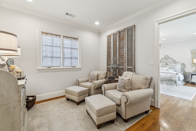 living area with wood finished floors, crown molding, recessed lighting, and baseboards