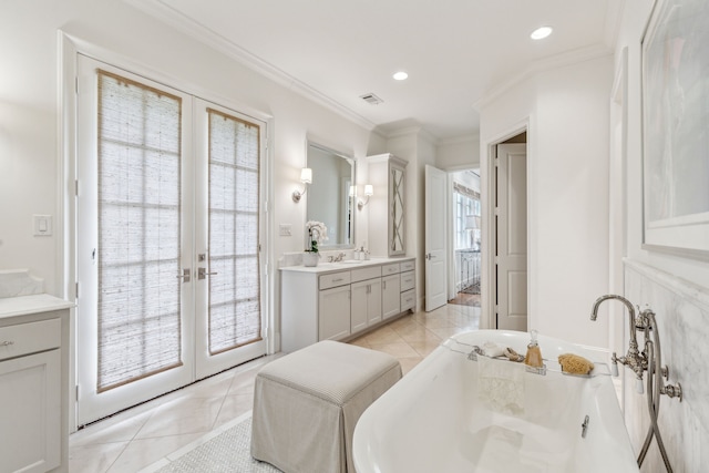 full bath with tile patterned flooring, french doors, a freestanding bath, vanity, and crown molding
