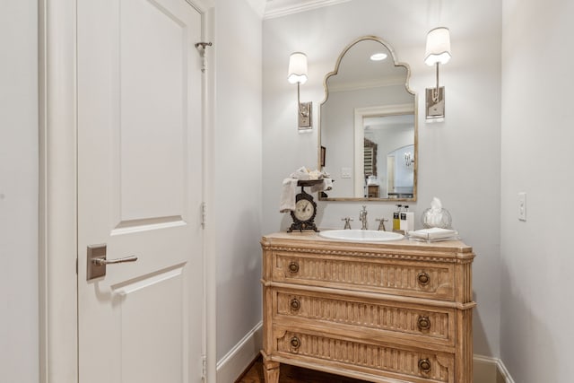 bathroom with crown molding, vanity, and baseboards