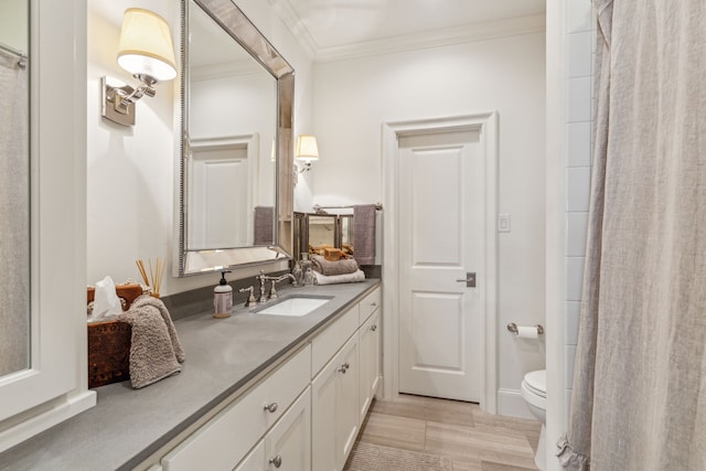bathroom featuring crown molding, vanity, and toilet