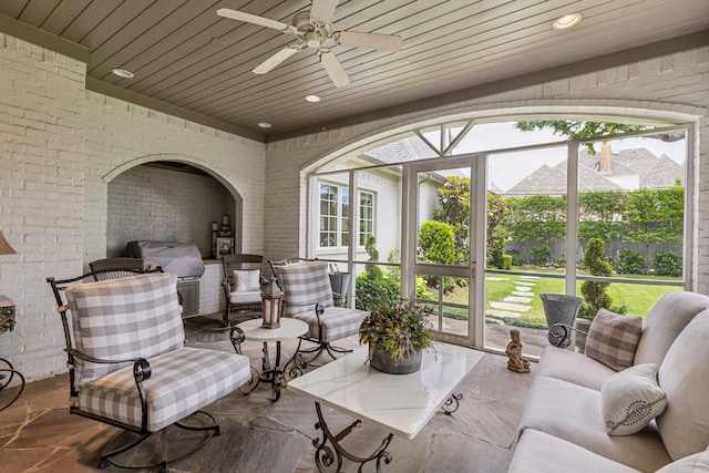 sunroom with plenty of natural light, a ceiling fan, and an outdoor living space