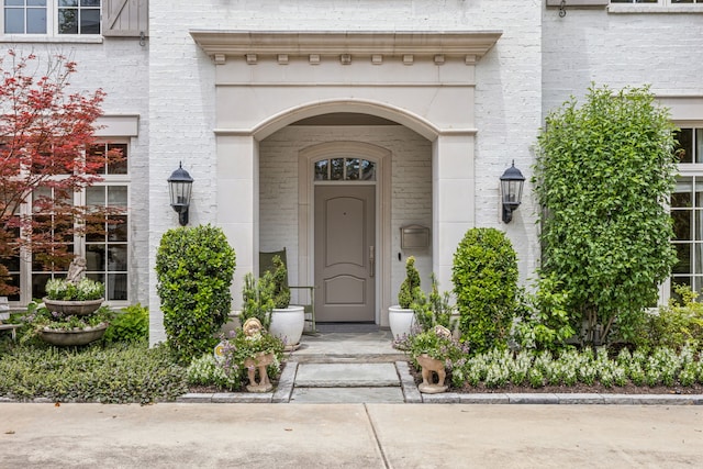 view of exterior entry with brick siding