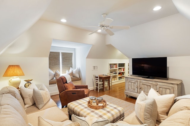 living room featuring vaulted ceiling, ceiling fan, wood finished floors, built in shelves, and recessed lighting
