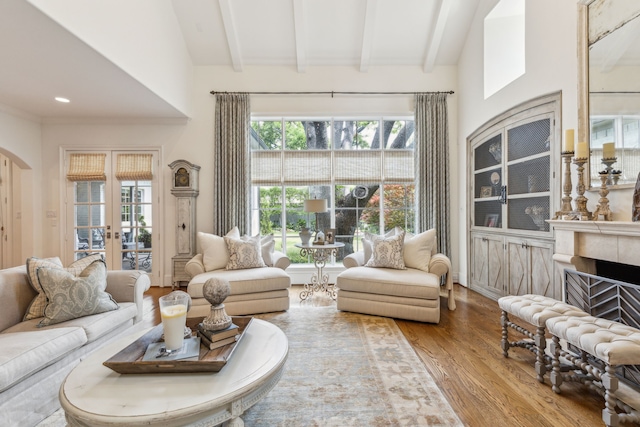living area with wood finished floors, french doors, arched walkways, and a fireplace