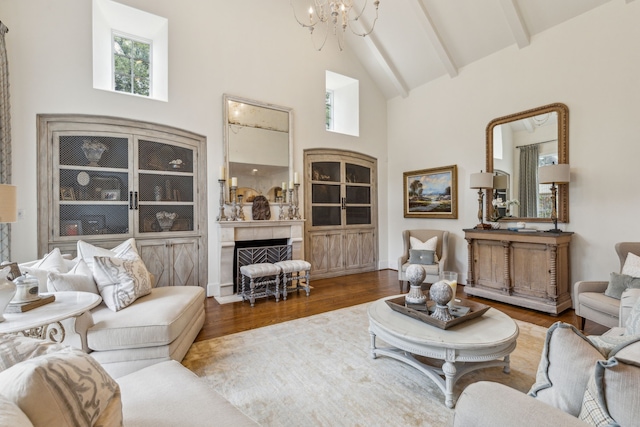 living area with high vaulted ceiling, a chandelier, plenty of natural light, a fireplace, and wood finished floors