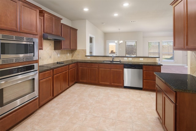 609 Racine Dr, Oak Point, TX 75068 - kitchen with stainless steel appliances, under cabinet range hood, a sink, tasteful backsplash, and recessed lighting