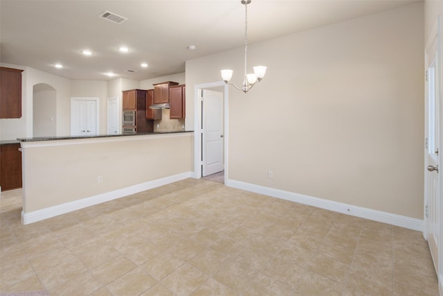 609 Racine Dr, Oak Point, TX 75068 - kitchen with dark countertops, a chandelier, recessed lighting, under cabinet range hood, and arched walkways