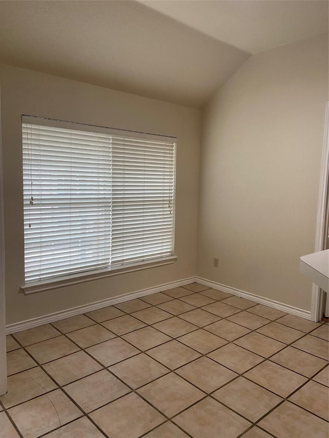 1102 N Main St, Leonard, TX 75452 - empty room featuring healthy amount of natural light, lofted ceiling, light tile patterned flooring, and baseboards