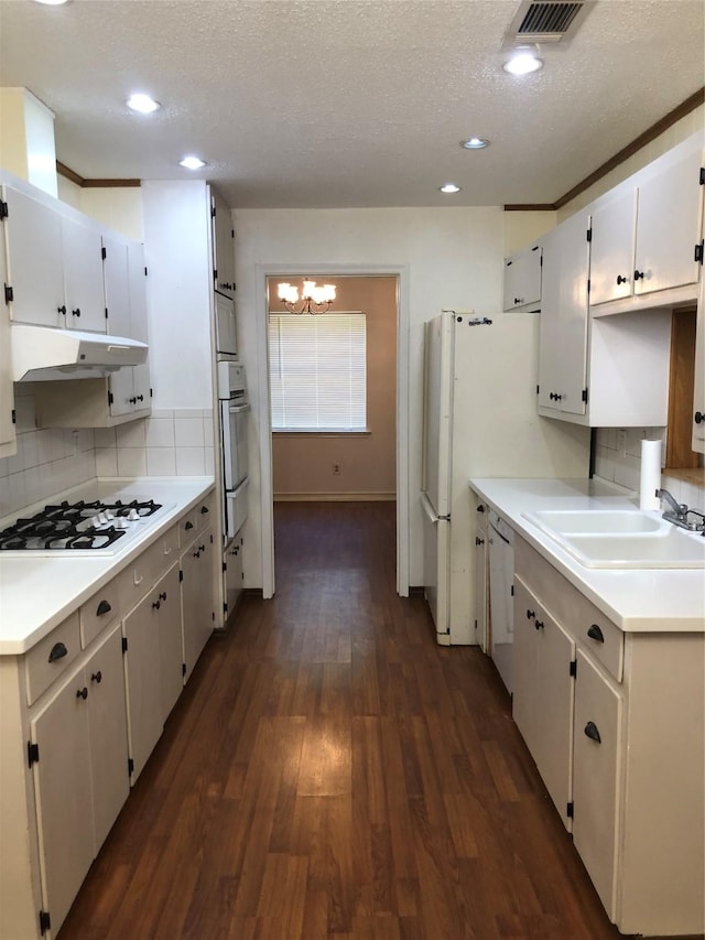 608 Spinner Rd, Desoto, TX 75115 - kitchen with white appliances, a sink, under cabinet range hood, a chandelier, and dark wood-style flooring