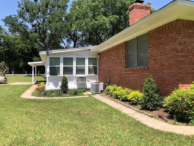 608 Spinner Rd, Desoto, TX 75115 - view of side of home with a chimney, brick siding, a yard, and central AC unit