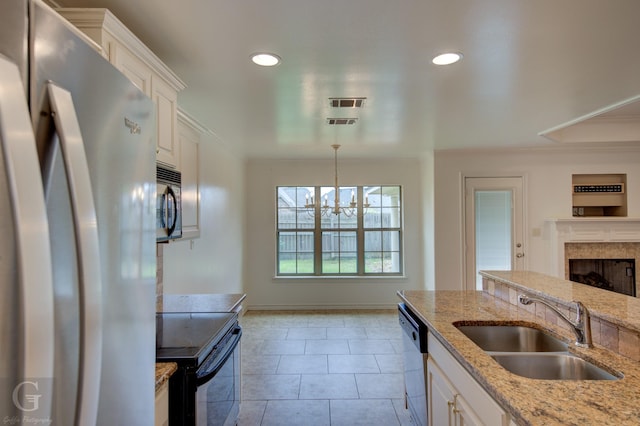 122 Lola Cir, Benton, LA 71006 - kitchen featuring freestanding refrigerator, black electric range, a sink, white cabinetry, and a fireplace