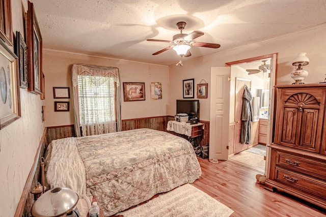 12815 N Fm 219, Dublin, TX 76446 - bedroom with light wood-type flooring, a wainscoted wall, a textured ceiling, wooden walls, and crown molding