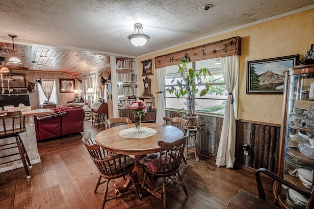 12815 N Fm 219, Dublin, TX 76446 - dining area with wood walls, hardwood / wood-style floors, a textured wall, and a textured ceiling