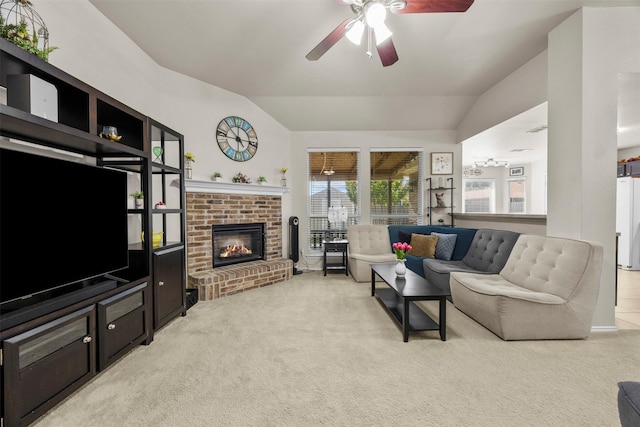 living room with ceiling fan, vaulted ceiling, light carpet, a fireplace, and plenty of natural light