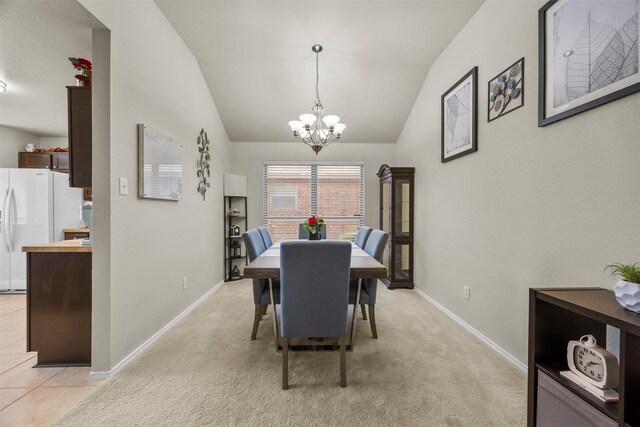 dining area featuring a chandelier, lofted ceiling, baseboards, and light colored carpet