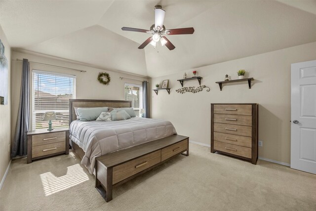 bedroom featuring light carpet, multiple windows, lofted ceiling, baseboards, and ceiling fan