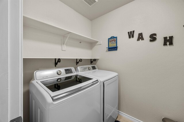 laundry area featuring separate washer and dryer and baseboards