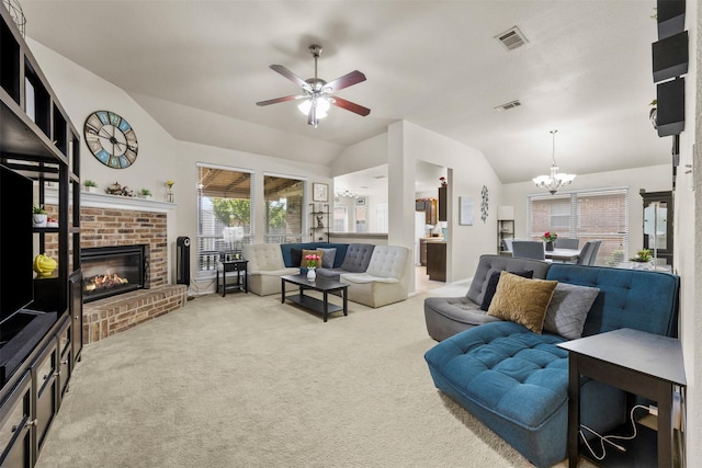 living area with vaulted ceiling, carpet floors, a chandelier, ceiling fan, and a fireplace