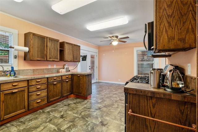 670 SE 22nd St SE, Paris, TX 75460 - kitchen with a sink, open shelves, stainless steel microwave, a ceiling fan, and crown molding