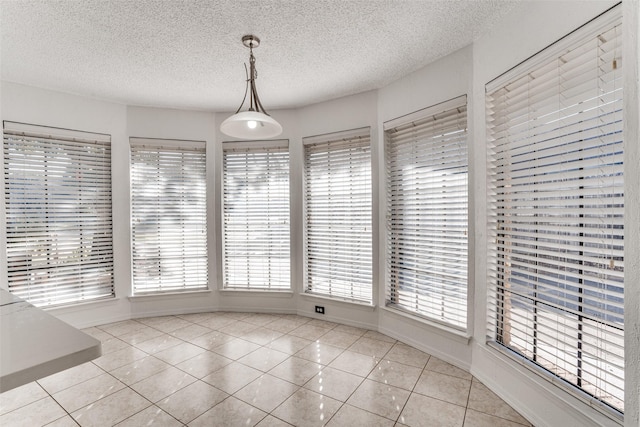 unfurnished dining area featuring light tile patterned floors and a textured ceiling
