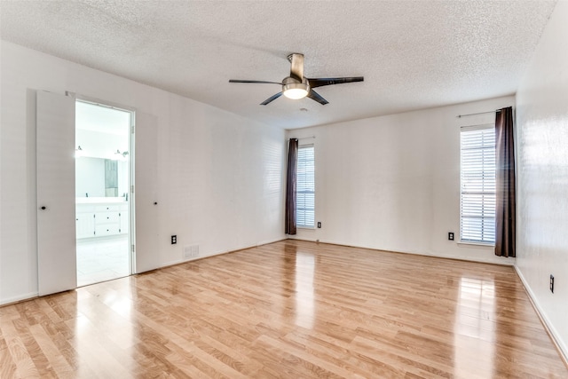 empty room with light wood-style flooring, ceiling fan, and a textured ceiling