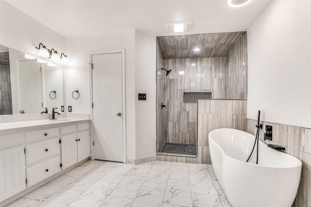 full bathroom with marble finish flooring, tiled shower, a soaking tub, and vanity