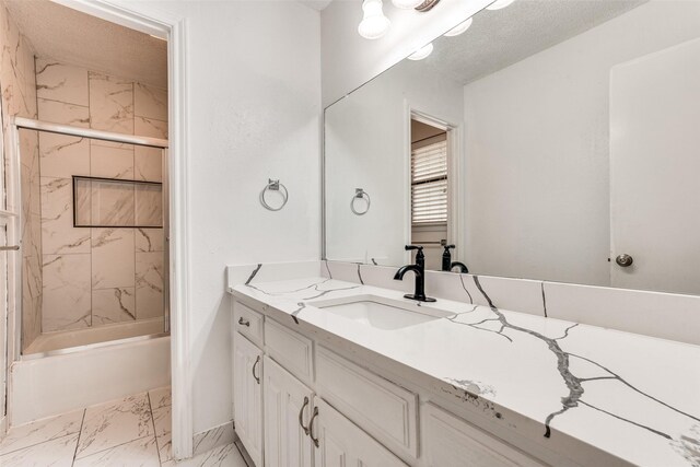 bathroom featuring marble finish floors, vanity, tub / shower combination, and baseboards
