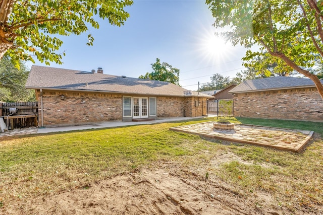 rear view of property with french doors, a fire pit, a patio area, brick siding, and a chimney