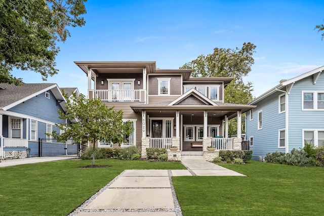 view of front of home featuring covered porch, a balcony, a front lawn, and a gate
