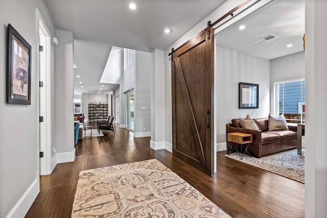 entryway with a barn door, baseboards, wood finished floors, and recessed lighting