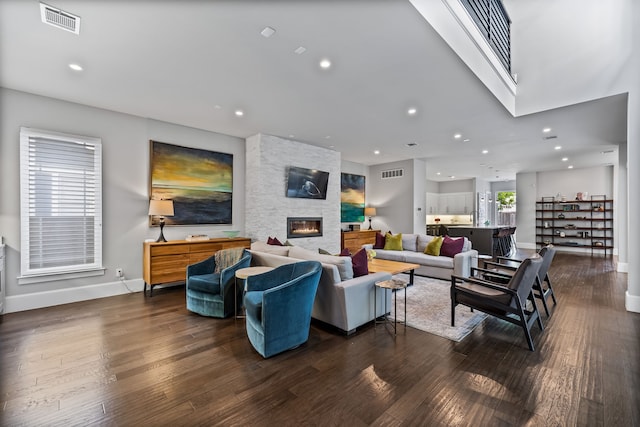 living area with baseboards, a fireplace, wood finished floors, and recessed lighting
