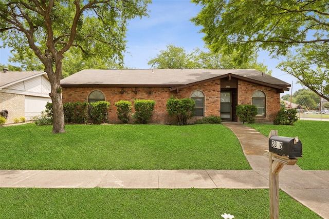 2302 Denmark Dr, Garland, TX 75040 - view of front facade featuring a front yard, brick siding, and a shingled roof