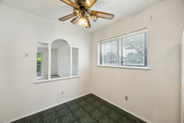 2302 Denmark Dr, Garland, TX 75040 - empty room featuring a ceiling fan, baseboards, and arched walkways