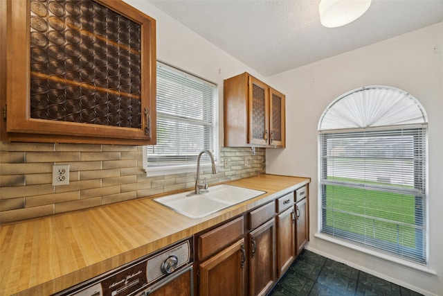 2302 Denmark Dr, Garland, TX 75040 - kitchen with a sink, tasteful backsplash, paneled dishwasher, and baseboards