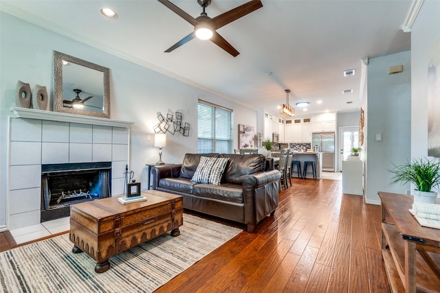 1219 Haines Ave, Dallas, TX 75208 - living room with a ceiling fan, hardwood / wood-style flooring, a tile fireplace, crown molding, and recessed lighting