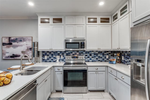 1219 Haines Ave, Dallas, TX 75208 - kitchen with appliances with stainless steel finishes, ornamental molding, light countertops, backsplash, and glass insert cabinets
