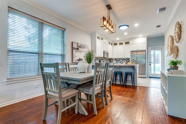 1219 Haines Ave, Dallas, TX 75208 - dining space with dark wood-type flooring, crown molding, and recessed lighting
