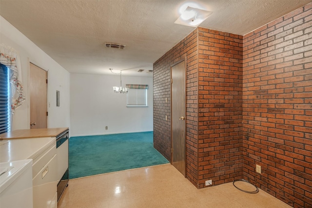 1406 E Cortez Dr, Wichita Falls, TX 76306 - corridor with a textured ceiling, brick wall, a chandelier, and carpet floors