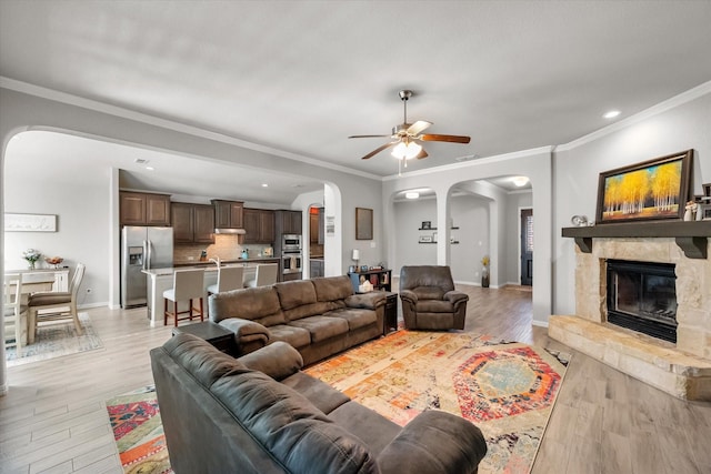 3626 Green Bluff Ct, Midlothian, TX 76065 - living area featuring arched walkways, light wood-type flooring, a ceiling fan, crown molding, and baseboards