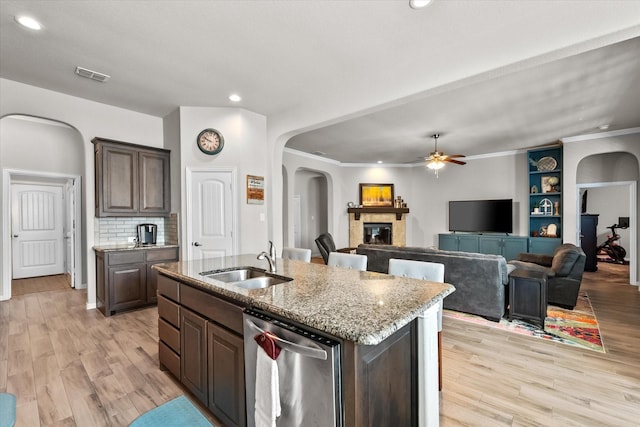 3626 Green Bluff Ct, Midlothian, TX 76065 - kitchen with a sink, arched walkways, stainless steel dishwasher, a ceiling fan, and light stone counters