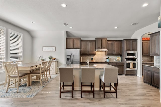 3626 Green Bluff Ct, Midlothian, TX 76065 - kitchen featuring stainless steel appliances, dark brown cabinetry, backsplash, an island with sink, and recessed lighting