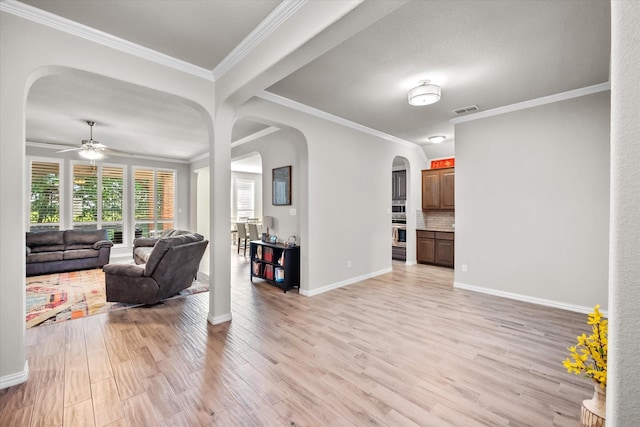 3626 Green Bluff Ct, Midlothian, TX 76065 - living room featuring arched walkways, light wood-style floors, a ceiling fan, baseboards, and crown molding