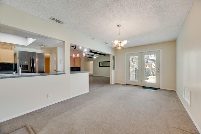 240 N Bryan Pl, Mesquite, TX 75149 - unfurnished living room with a chandelier, light carpet, a textured ceiling, baseboards, and a ceiling fan