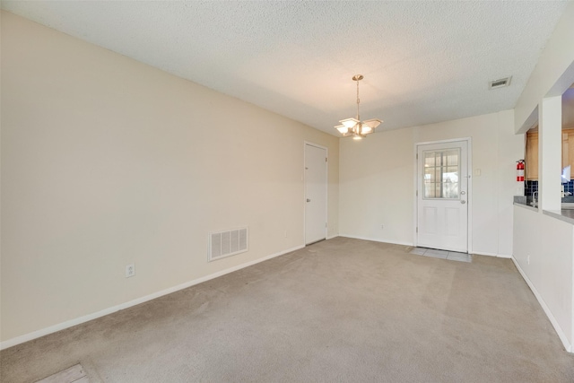 240 N Bryan Pl, Mesquite, TX 75149 - empty room featuring light colored carpet, a chandelier, baseboards, and a textured ceiling