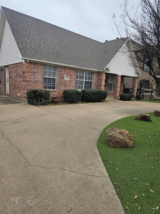 3233 S Univ Dr, Fort Worth, TX 76109 - view of front of house with brick siding, a shingled roof, and curved driveway