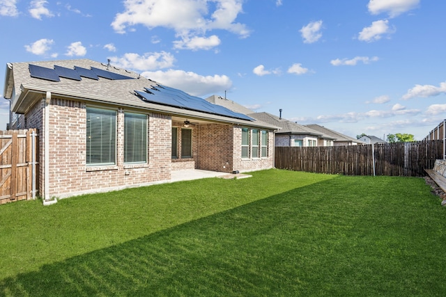 5408 Fairdale Dr, Denton, TX 76207 - back of property with brick siding, a patio area, roof mounted solar panels, ceiling fan, and a shingled roof