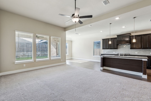 5408 Fairdale Dr, Denton, TX 76207 - kitchen with custom exhaust hood, open floor plan, a sink, baseboards, and recessed lighting